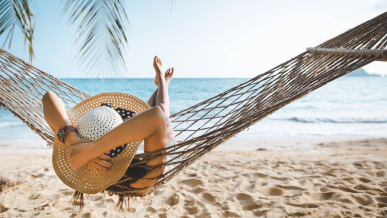 Adobe Stock - Woman in hammock with palm tree, ocean and sand