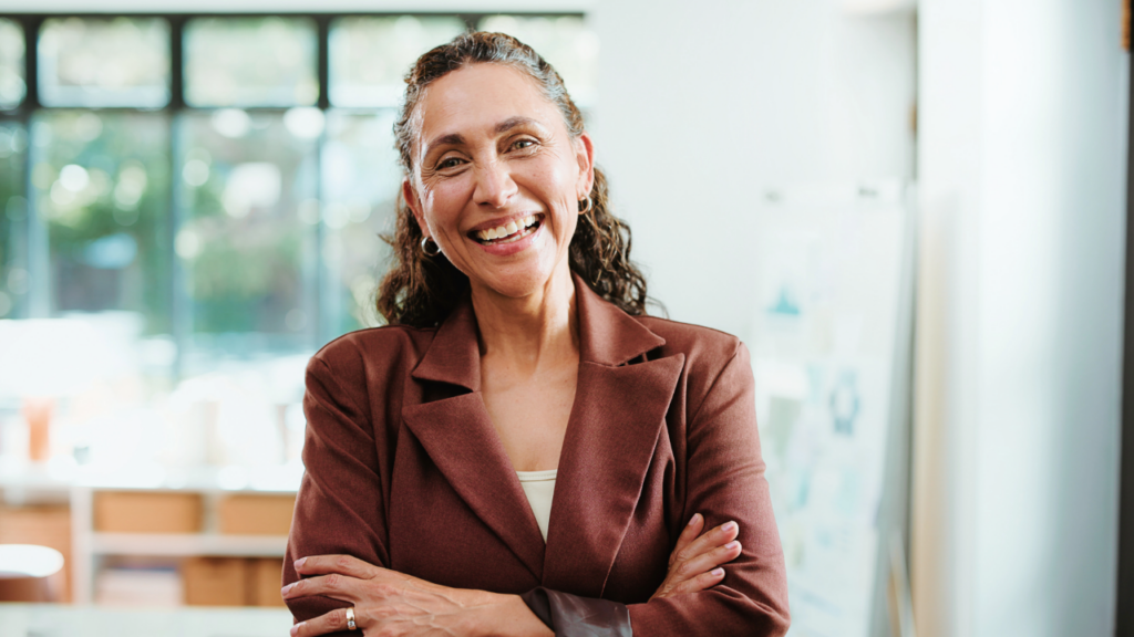 Woman with her arms crossed smiling confidently.